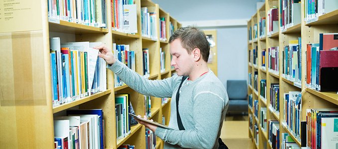 Student between shelves in TUAS library